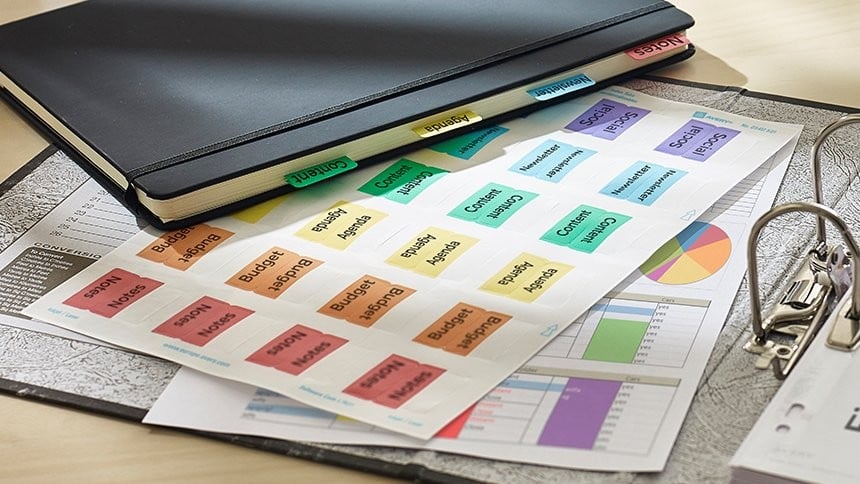 Indici divisori colorati stampati posizionati accanto un raccoglitore