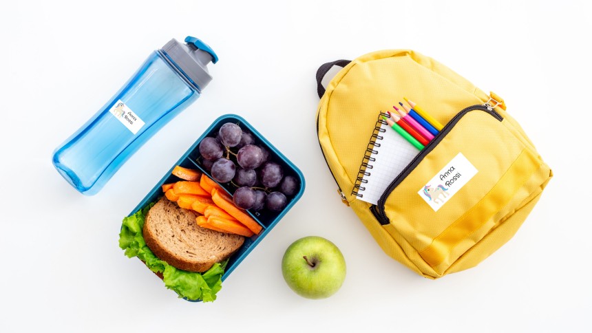 materiale scolastico disposto su un tavolo con applicate delle etichette stampate