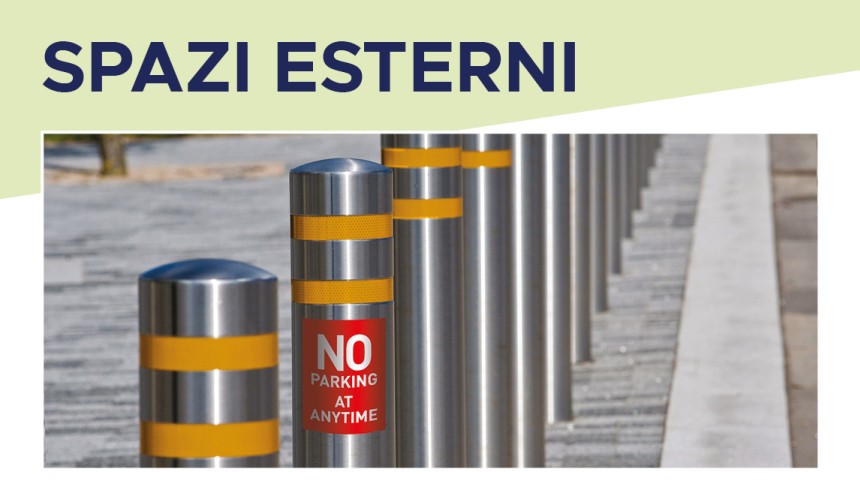 Colonnine di sicurezza in metallo con strisce gialle e etichette adesive in un'area esterna