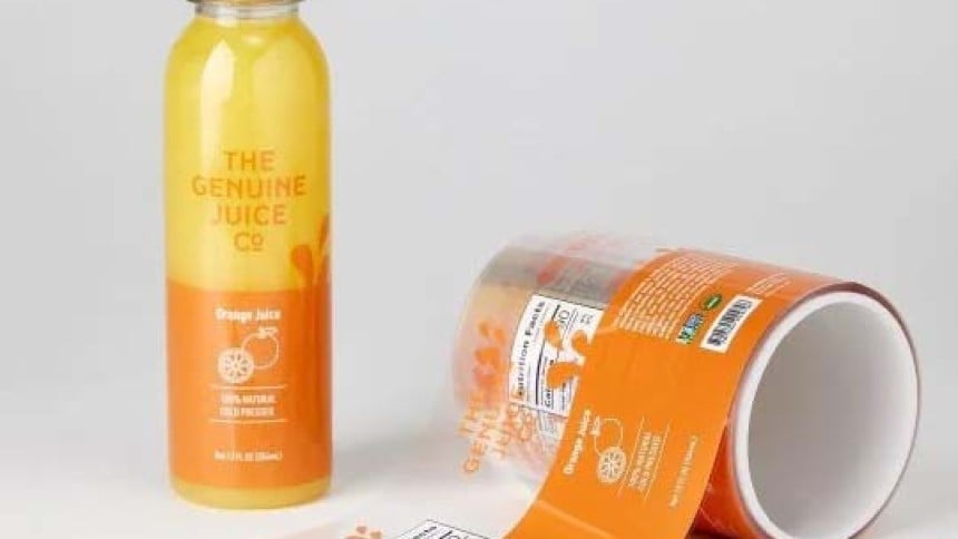 Bottiglia di vetro con etichetta adesiva arancione e rotolo di etichette stampate con lo stesso testo