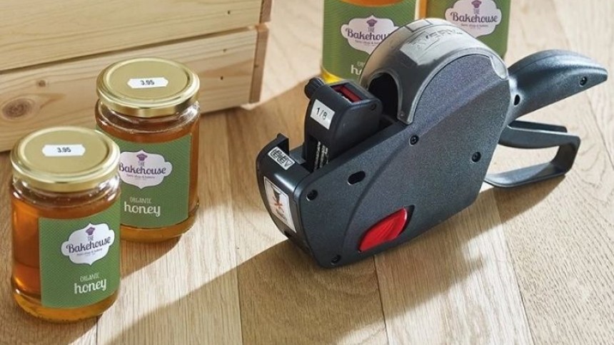 una prezzatrice accanto a dei barattoli etichettati