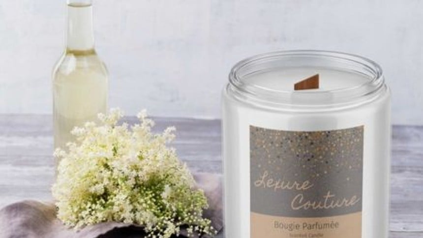 una candela bianca con applicata una etichetta in carta kraft stampata