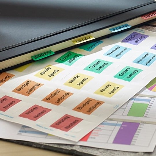 Indici divisori colorati stampati posizionati accanto un raccoglitore