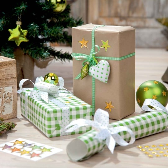 vari pacchetti di natale decorati con adesivi natalizi