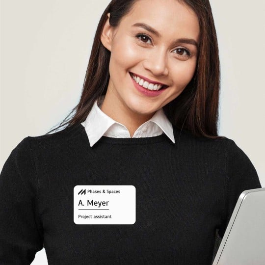 ragazza con maglia nera con applicato un badge adesivo rettangolare con stampato il suo nome