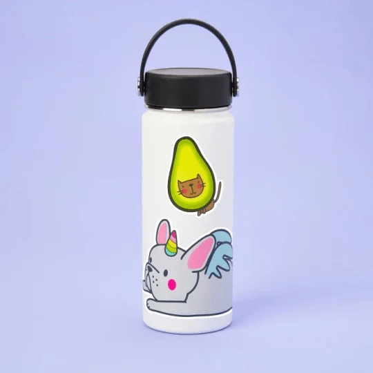 Borraccia bianca con adesivi di un avocado e un unicorno su sfondo viola