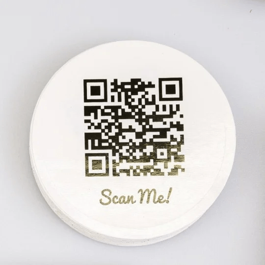 adesivo rotondo bianco con stampato codice QR e scritta Scan me