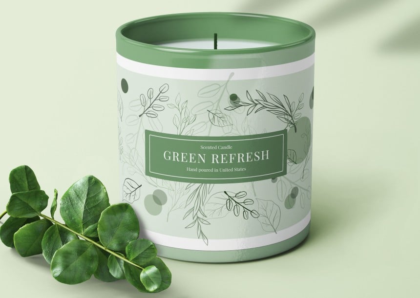 candela in un vasetto verde con etichetta rettangolare stampata che avvolge tutto il vasetto
