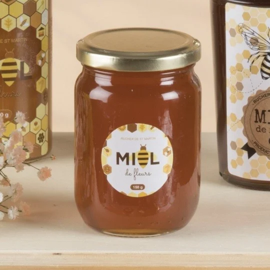 Barattolo di miele con etichetta rotonda stampata con decorazioni floreali, tappo dorato