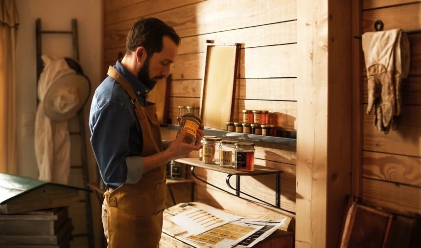Uomo che lavora il miele, utilizzando strumenti di legno su un banco da lavoro