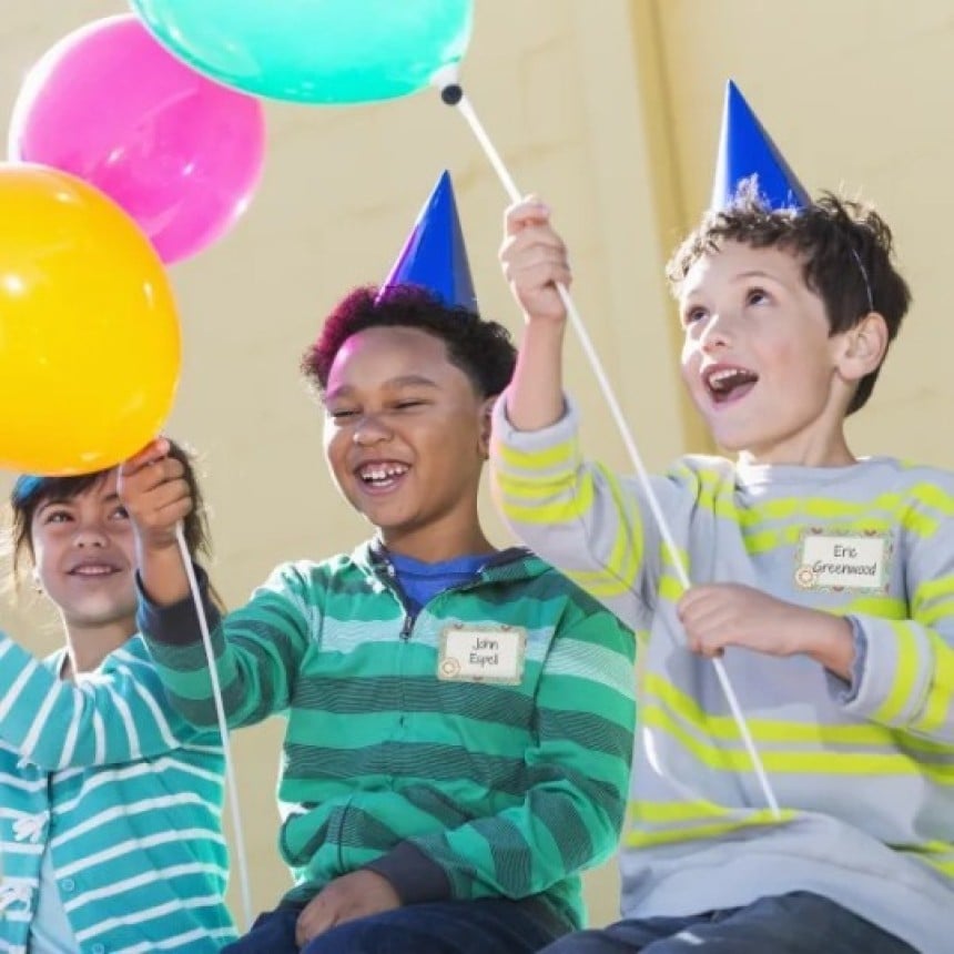 Bambini ad una festa con badge adesivi con i loro nomi applicati sui testi