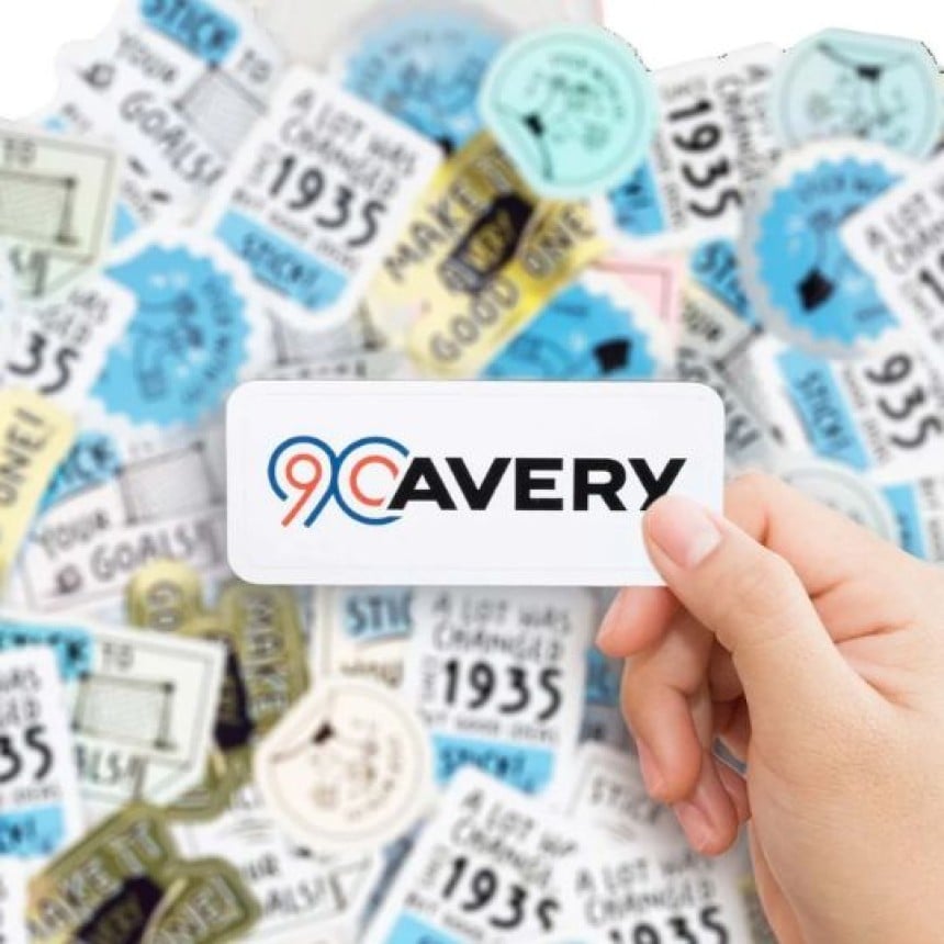 mano che mostra un adesivo con stampato il logo 90 anni di Avery