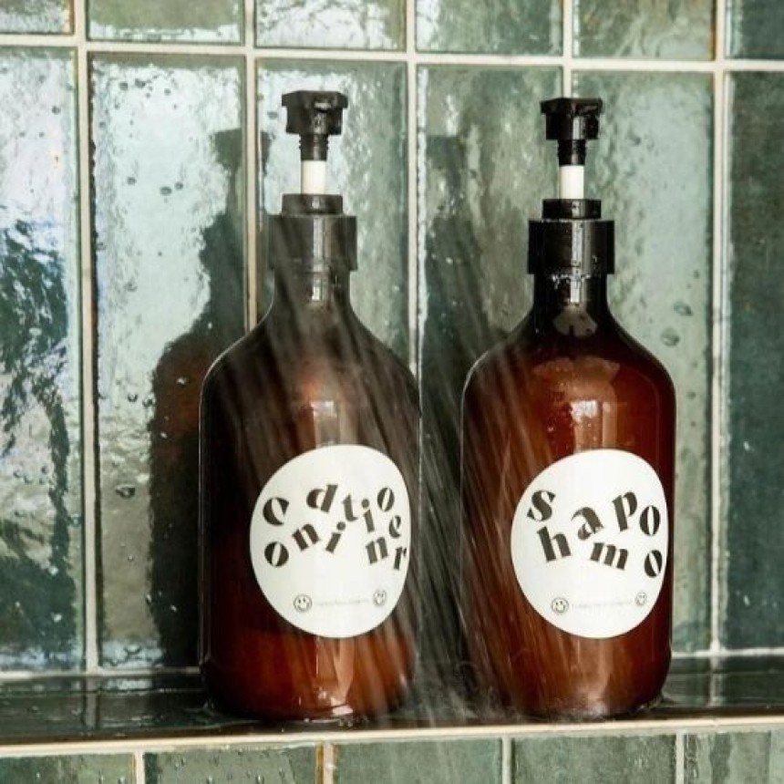 Bottiglie di sapone con etichette adesive su uno scaffale