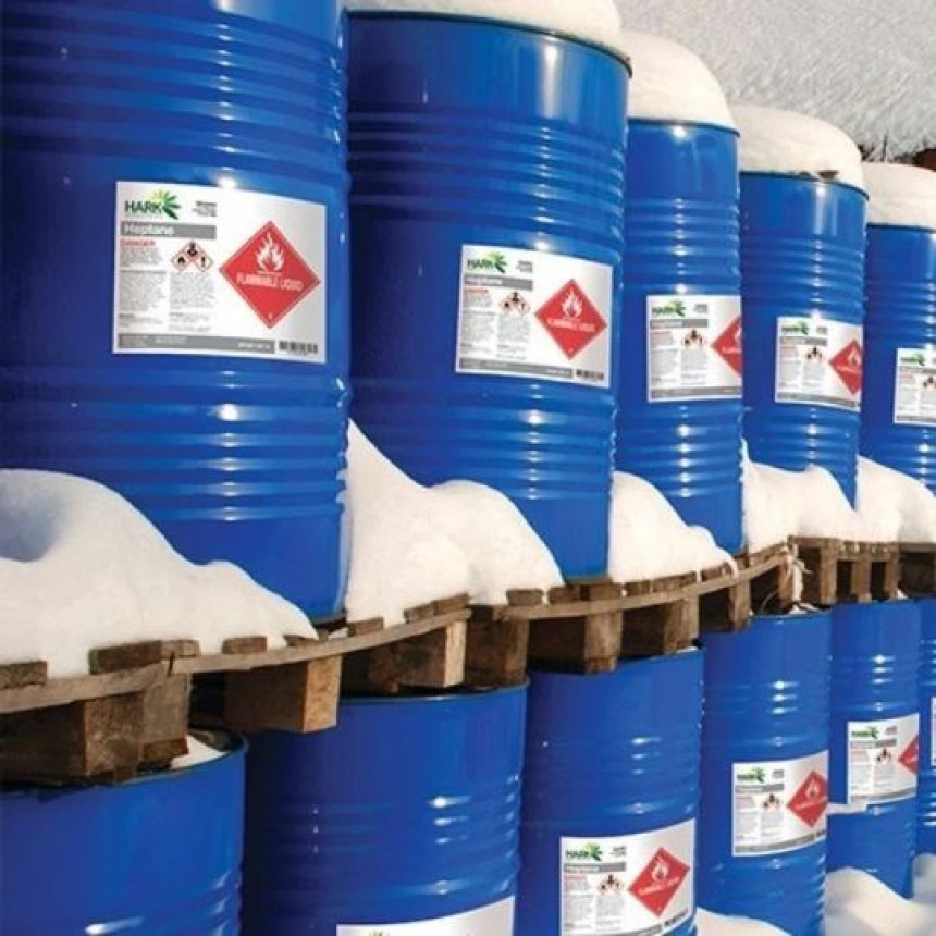 File di barili blu con etichette adesive stampate con le informazioni di pericolo