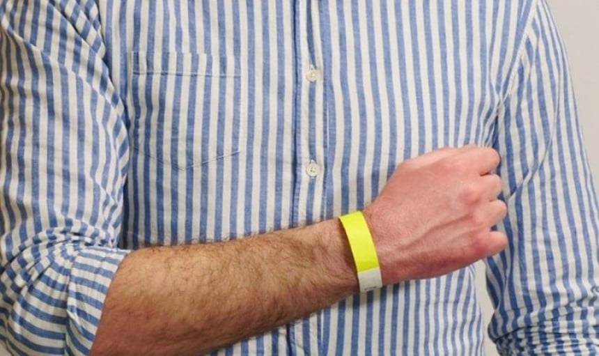 persona che indossa un braccialetto giallo al polso
