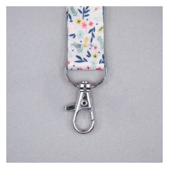 Lanyard with a floral design and a metal clip attachment.