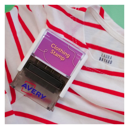 L'immagine mostra una maglietta a righe rosse e bianche con uno stampo per vestiti Avery appoggiato su di essa. L'etichetta dello stampo dice 'Clothing Stamp'.