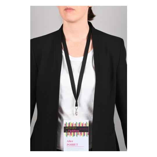 L'immagine mostra una persona con un abito nero e una maglietta bianca, indossando un badge di partecipazione a un seminario, che include il nome 'Alice Poiret'.