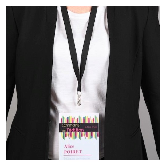 L'immagine mostra una persona con indosso un blazer nero e una maglietta bianca. Ha un badge appeso al collo che reca il nome 'Alice POIRET' con contrassegno di un seminario.