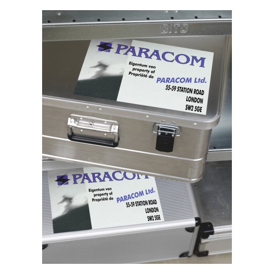 L'immagine mostra due scatole metalliche con un'etichetta scritta 'PARACOM Ltd.' e indirizzi in Londra. L'etichetta presenta anche un simbolo, in un design professionale.