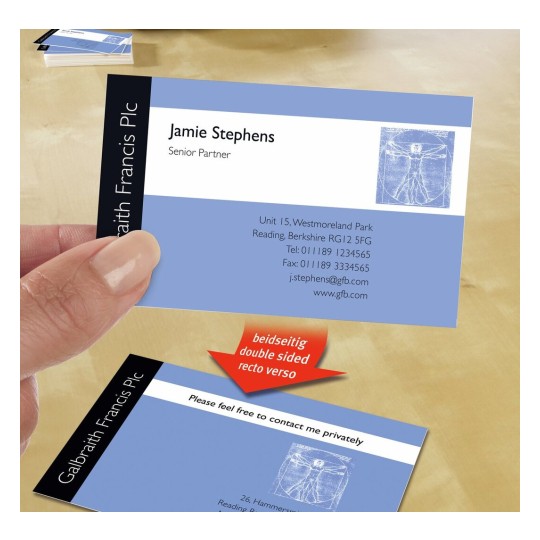 The image displays a business card held in a person's hand. The card features the name 'Jamie Stephens' with the title 'Senior Partner' below. The card includes contact information, including an address, telephone, fax number, and email. It shows a background design with a blue color and a sketch inspired by Leonardo da Vinci's 'Vitruvian Man.' Another card below has a message indicating it is double-sided.