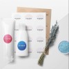 tre cosmetici con applicate delle etichette rotonde stampate su un tavolo sopra dei fogli delle stesse etichette