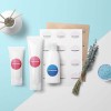 tre cosmetici con applicate delle etichette rotonde stampate su un tavolo sopra dei fogli delle stesse etichette