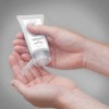 mani che utilizzano un tubetto di crema