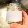 mano che mostra come rimuovere una etichetta con l'acqua