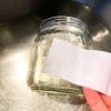 mano che mostra come rimuovere una etichetta con l'acqua