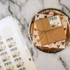 Scatola marrone con etichette adesive quadrate stampata e foglio di etichette sullo sfondo