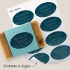 Un foglio di etichette ovali stampate blu su foglio e applicate su una saponetta