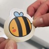 mani che mostrano uno stickers stampato con un ape