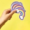 Mano che tiene adesivi stampati a forma di arcobaleno