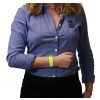 L'immagine mostra una donna con i capelli ricci, che indossa una camicia blu e ha un braccialetto giallo al polso. Sta tenendo il braccio con le mani incrociate.