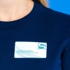 Un'immagine di una persona che indossa una maglietta blu scuro con un badge identificativo che riporta il nome 'Emma Garcia' e il titolo 'Project Manager'.