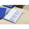 The image displays a binder organized with labeled tabs including Agenda, Presentation, Actions, Conferences, Details, Budgets, Promotion, Clients, Transport, and Distribution. It sits on a desk with a blue folder and a black storage box in the background.