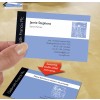 The image displays a business card held in a person's hand. The card features the name 'Jamie Stephens' with the title 'Senior Partner' below. The card includes contact information, including an address, telephone, fax number, and email. It shows a background design with a blue color and a sketch inspired by Leonardo da Vinci's 'Vitruvian Man.' Another card below has a message indicating it is double-sided.