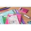 L'immagine mostra una serie di materiali scolastici tra cui quaderni colorati, un calcolatore rosa, un righello e forbici. I quaderni hanno etichette con nomi di materie scolastiche come 'Français' e 'Histoire-Géo'.