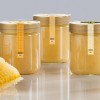 barattoli di miele con applicate sul tappo delle etichette sigillo stampate con le informazioni di prodotto