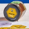 barattolo di miele con applicata sul tappo una etichetta esagonale stampate con il marchio del miele
